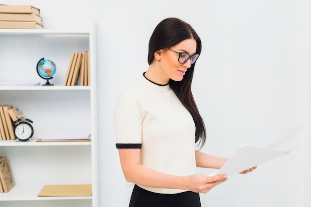 Jeune femme, debout, papiers, bureau