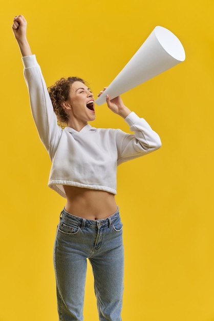 Photo gratuite jeune femme debout parlant dans un mégaphone