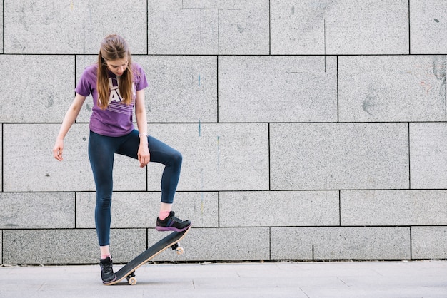 Jeune femme debout avec planche à roulettes