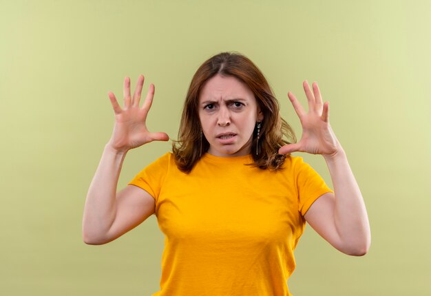 Jeune femme décontractée en colère avec les mains levées sur un espace vert isolé