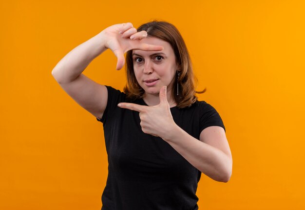 Jeune femme décontractée faisant des gestes sur un mur orange isolé avec espace de copie