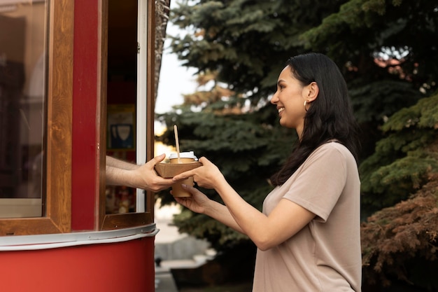 Photo gratuite jeune femme dégustant de délicieux plats de rue