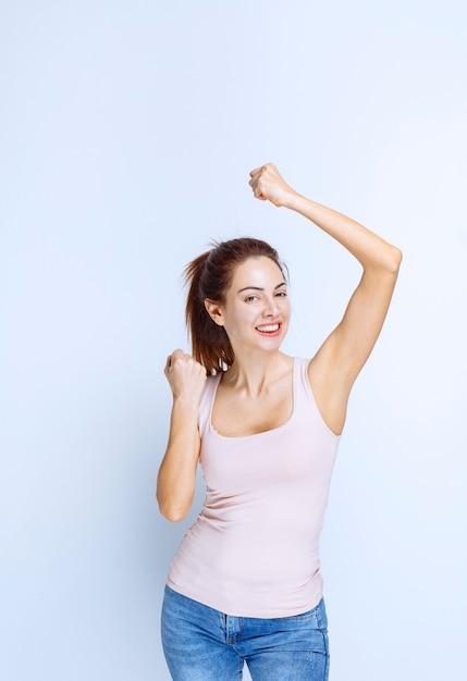 Jeune femme démontrant ses muscles du bras, vue de profil