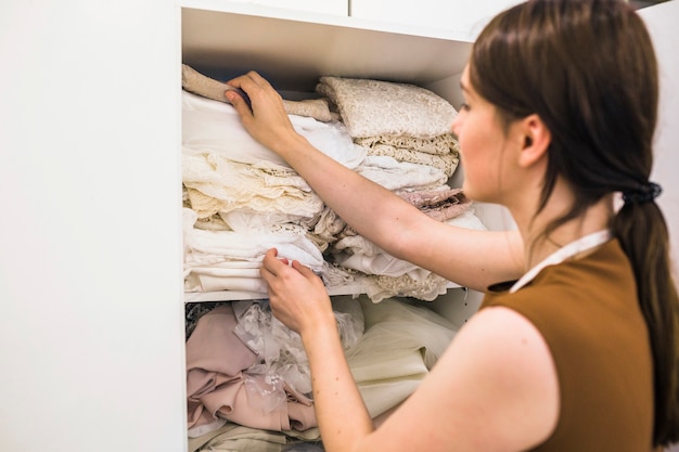 Jeune femme designer choisir le tissu de l&#39;étagère