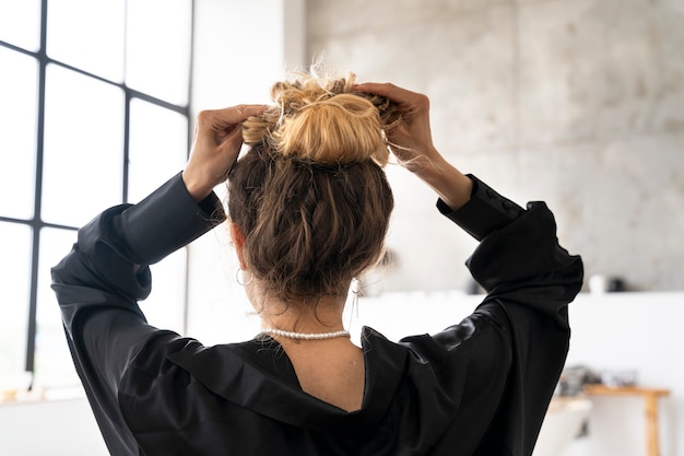 Photo gratuite jeune femme, à, désordonné, chignon, coiffure