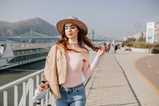 Photo gratuite jeune femme détendue joue avec les cheveux rouges sur les montagnes