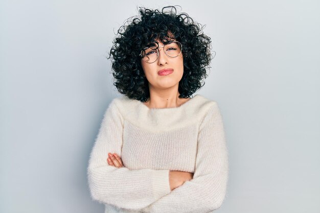 Jeune femme du moyen-orient avec les bras croisés geste désemparé et expression confuse concept de doute