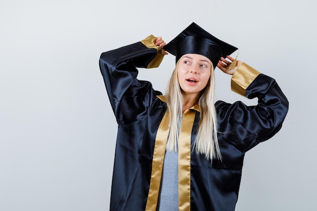 Jeune femme à l'écart en robe académique et à la surprise