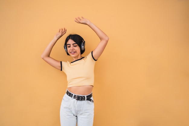 Jeune femme écoutant de la musique avec des écouteurs.