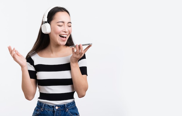 Photo gratuite jeune femme écoutant de la musique sur mobile