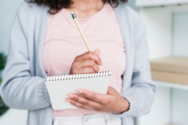 Jeune femme écrivant dans le bloc-notes