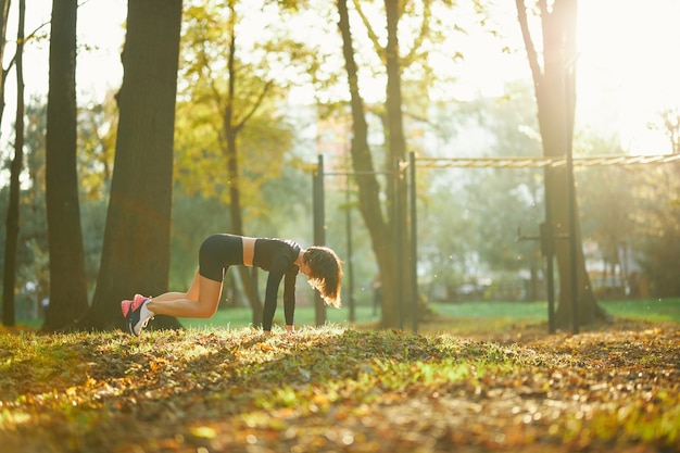 Jeune femme effectuant en pilates au parc de la ville