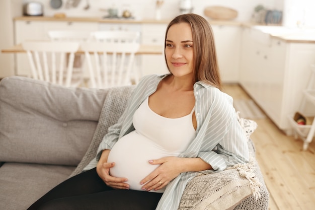 Jeune femme enceinte, poser, intérieur