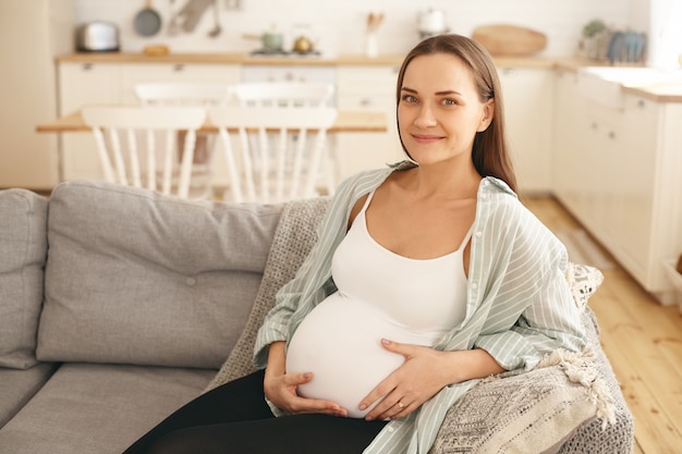 Jeune femme enceinte, poser, intérieur