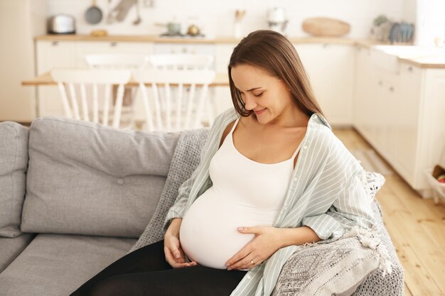 Jeune femme enceinte, poser, intérieur