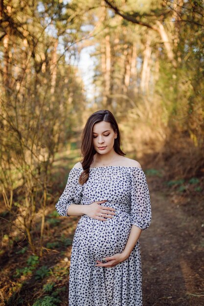 Jeune femme enceinte se détendre dans le parc en plein air