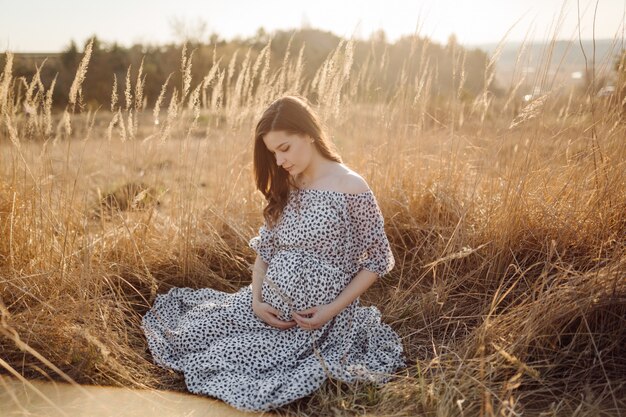 Jeune femme enceinte se détendre dans le parc en plein air