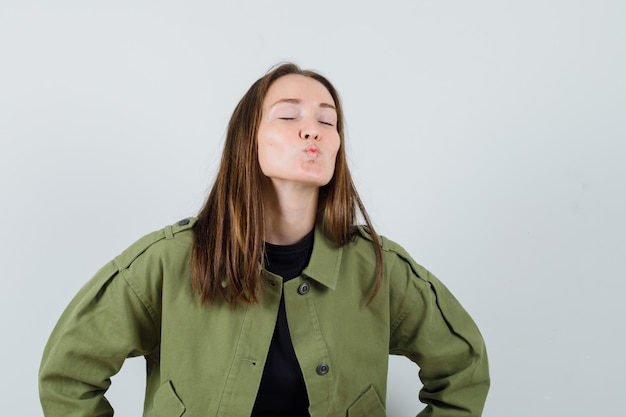 Photo gratuite jeune femme envoi de baiser d'air en vue de face de veste verte.