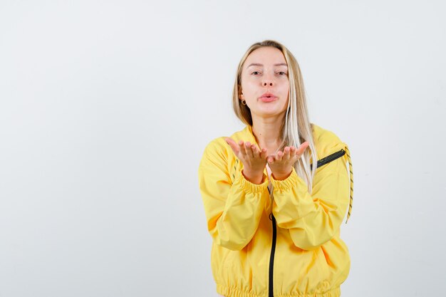 Jeune femme envoyant un baiser avec la main en t-shirt, veste et à mignon