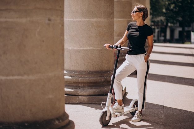 Photo gratuite jeune femme, équitation, scotter, bâtiment université