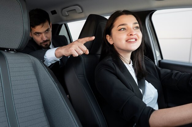 Jeune femme étant un chauffeur uber pour un client masculin