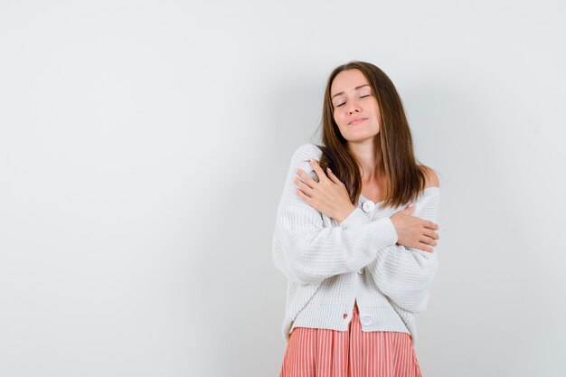 Jeune femme, étreindre, dans, cardigan, et, jupe, regarder, somnolent, isolé