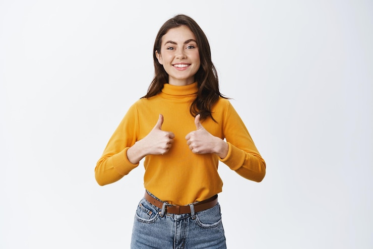 Photo gratuit jeune femme excitée montrant un soutien total et souriant en signe d'approbation dire oui d'accord ou approuver la fille aime le bon choix recommandant le produit fond blanc