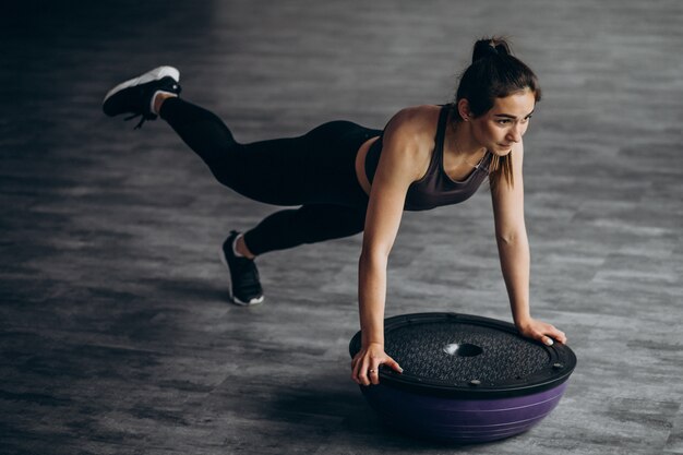 Jeune femme exerçant dans la salle de gym avec poids