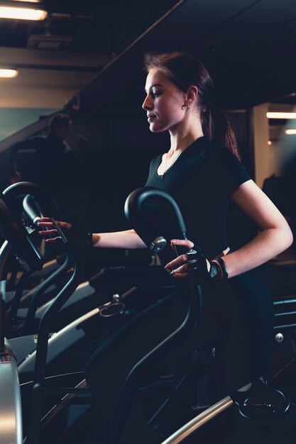 Jeune femme exerçant sur une machine cardio elliptique