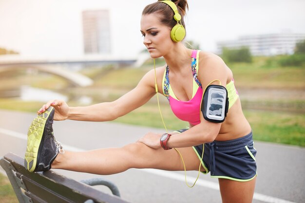 Jeune femme exerçant en plein air. Faites des étirements pour éviter des blessures