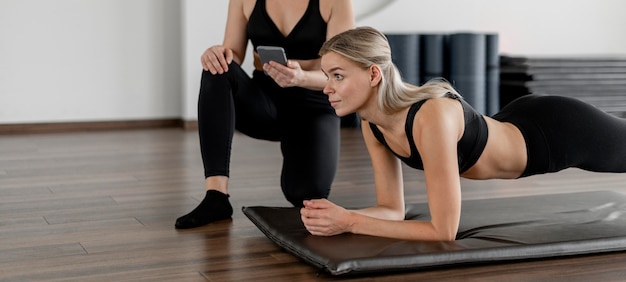 Jeune femme exerçant à la salle de sport faisant une planche