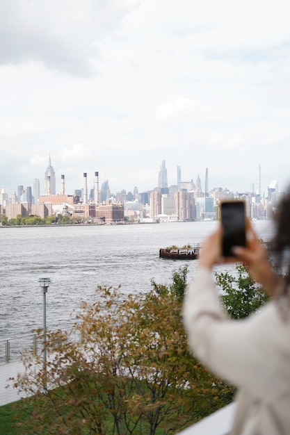 Jeune femme explorant la ville tout en utilisant un smartphone