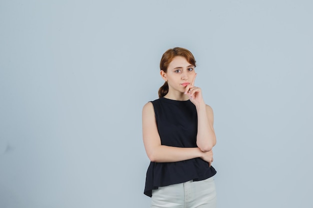 Jeune femme expressive posant dans le studio