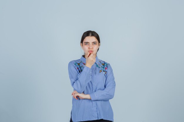 Jeune femme expressive posant dans le studio