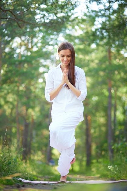 Jeune femme faisant la classe de yoga dans le parc