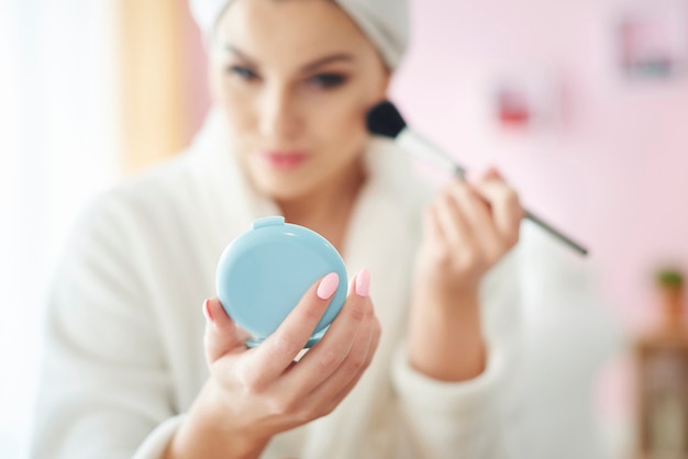 Jeune femme faisant du maquillage le matin