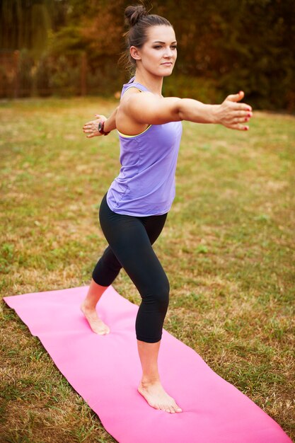 Jeune femme faisant du yoga à l'extérieur. Cette position seule peut sembler facile