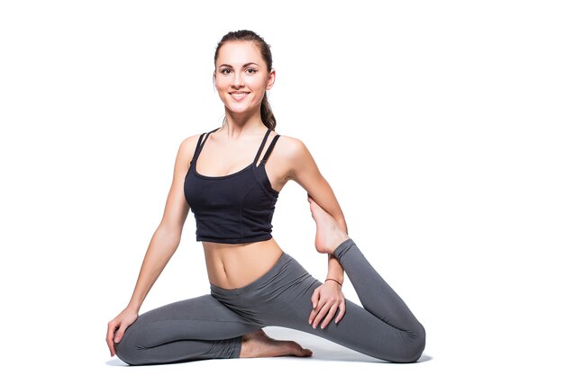 Jeune femme faisant du yoga sur fond blanc