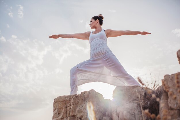 Jeune femme faisant de l&#39;exercice de yoga sur le rock