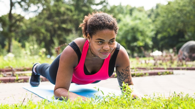 Jeune femme faisant des exercices dans le parc