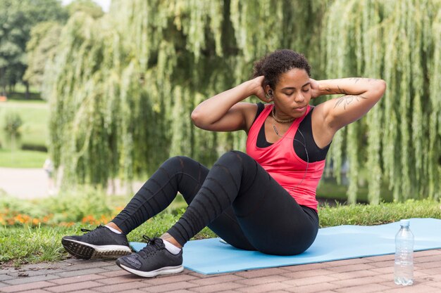 Jeune femme faisant des exercices dans le parc