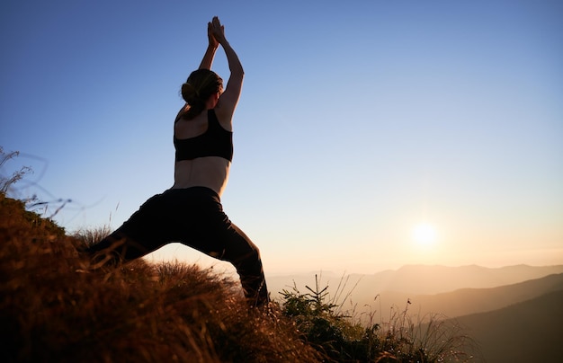 Jeune femme faisant des exercices de yoga sur la nature