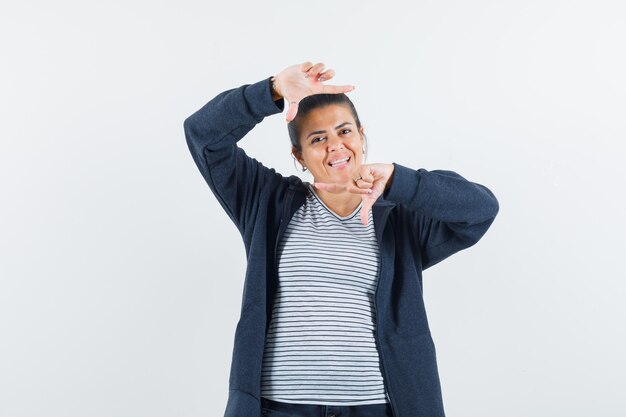 Jeune femme faisant un geste de cadre en t-shirt