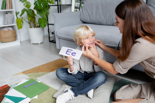 Jeune femme faisant de l'orthophonie avec un petit garçon blond