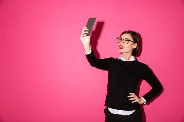 Photo gratuite jeune femme faisant selfie sur smartphone isolé