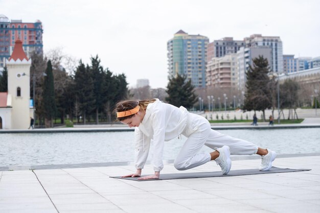Une jeune femme faisant ses exercices au parc devant le lac Photo de haute qualité