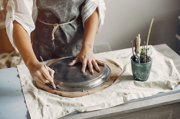 Jeune femme fait de la poterie en atelier