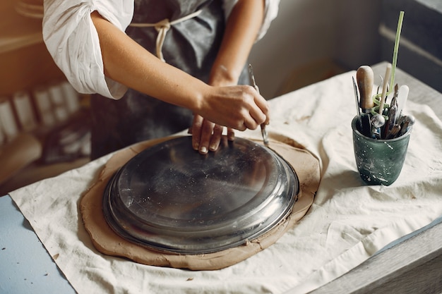 Jeune femme fait de la poterie en atelier