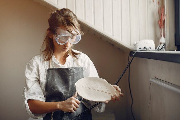 Jeune femme fait de la poterie en atelier