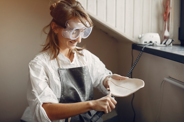 Photo gratuite jeune femme fait de la poterie en atelier